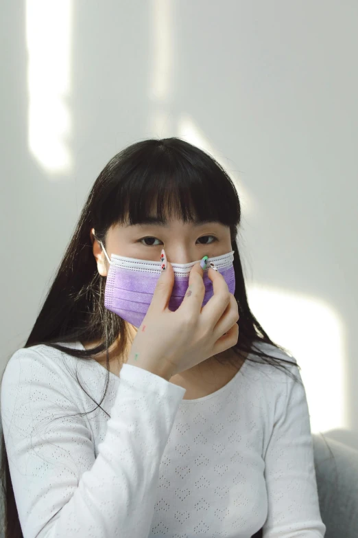 a woman wearing a face mask while sitting on a couch, by helen huang, happening, wearing purple undershirt, ((purple)), teenage girl, nasal strip