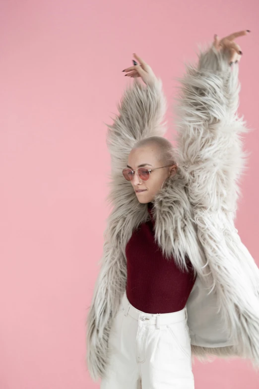 a woman in white pants and a furry coat, an album cover, inspired by Ren Hang, trending on pexels, antipodeans, bald, excitement, kailee mandel, grey skinned