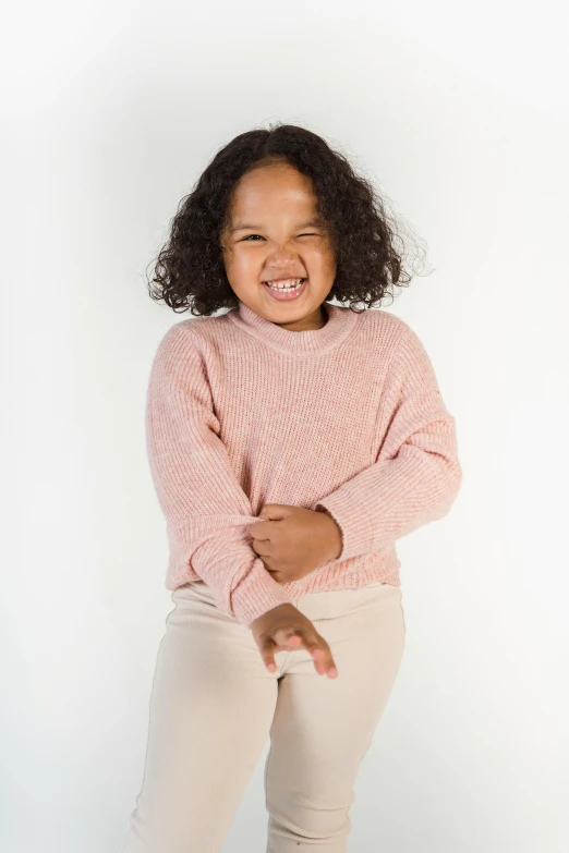 a little girl in a pink sweater posing for a picture, by Daniel Seghers, for junior, smooggy, mixed race, promotional image