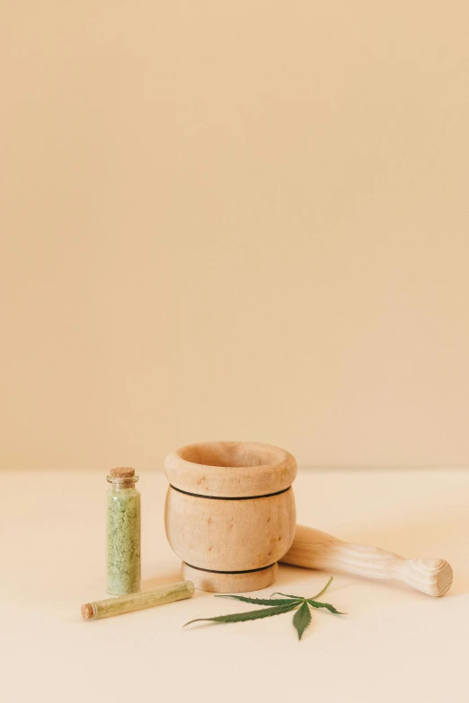 a wooden bowl sitting on top of a table, a picture, mortar and pestle, pastel green, detailed product image, crack pipe