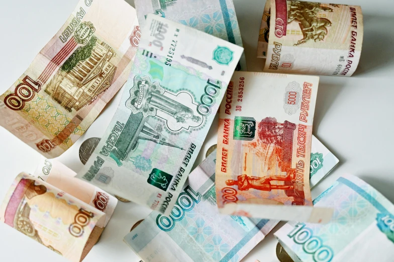 a pile of money sitting on top of a table, by Vladimir Borovikovsky, hurufiyya, multicoloured, promo image, three quater notes, thumbnail