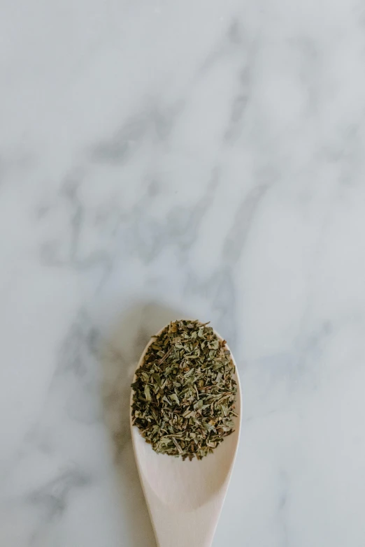 a wooden spoon filled with dried herbs on a marble surface, a picture, trending on pexels, renaissance, full body image, jovana rikalo, high quality product photography, portrait of small