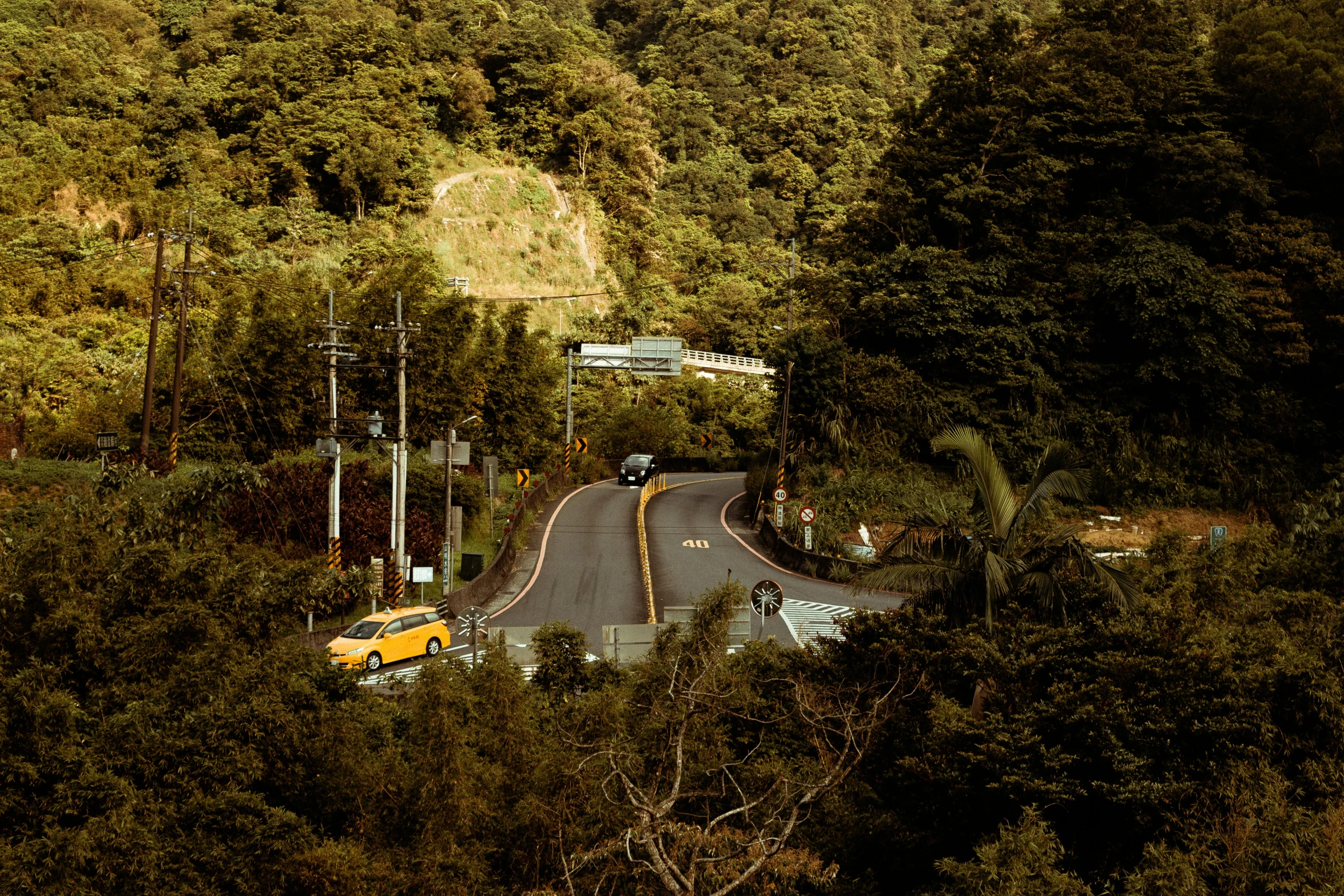 a yellow car driving down a winding road, by Elsa Bleda, visual art, puerto rico, kamakura scenery, thumbnail, brown