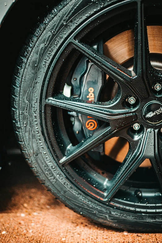 a close up of a tire on a car, inspired by An Gyeon, black and orange, black on black. intricate, lightweight, thumbnail