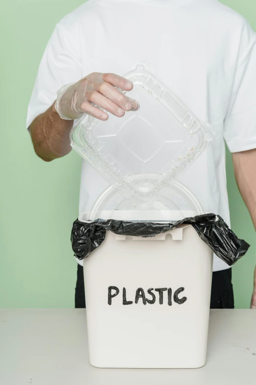 a man putting a plastic bag into a trash can, an album cover, by Dan Content, shutterstock, plasticien, 15081959 21121991 01012000 4k, resin, eco, contain