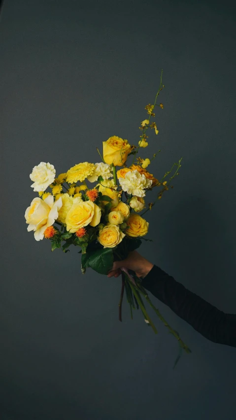 a woman holding a bunch of yellow and white flowers, a still life, inspired by William Yellowlees, unsplash, dark backdrop, gradient yellow, made of glazed, various posed