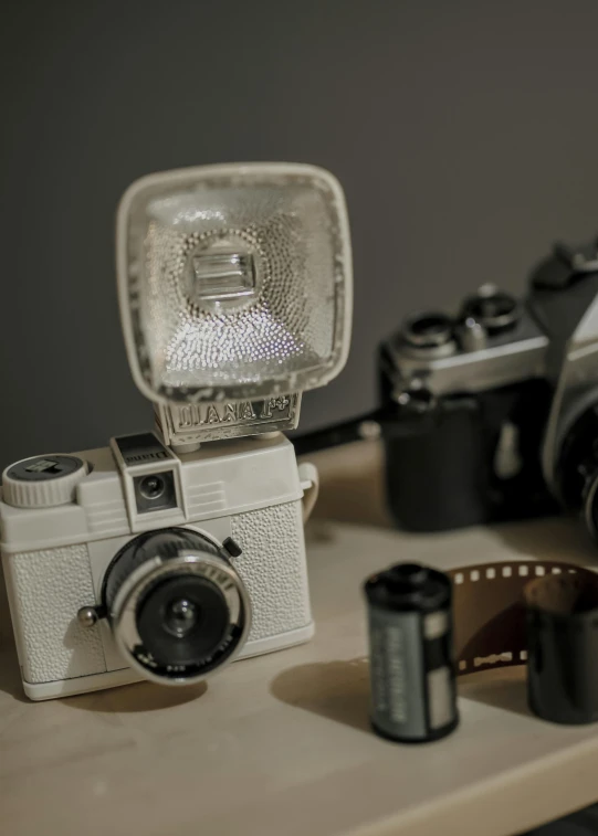 a couple of cameras sitting on top of a table, toy camera, stippled light, film artifacts, fan favorite