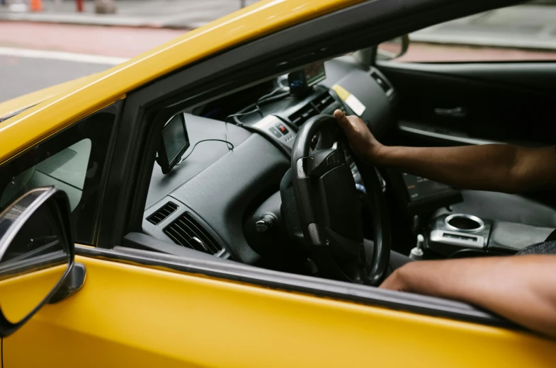 a man sitting in the driver's seat of a yellow car, pexels contest winner, dark-skinned, emma uber, aftermarket parts, sydney hanson