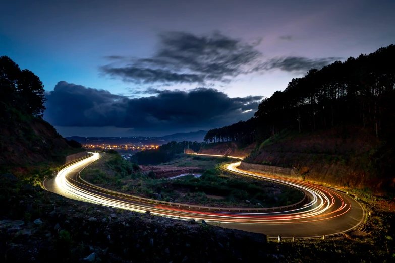 a long exposure photo of a winding road at night, by Matt Stewart, unsplash contest winner, azores, racing, ultrawide lens”, cars