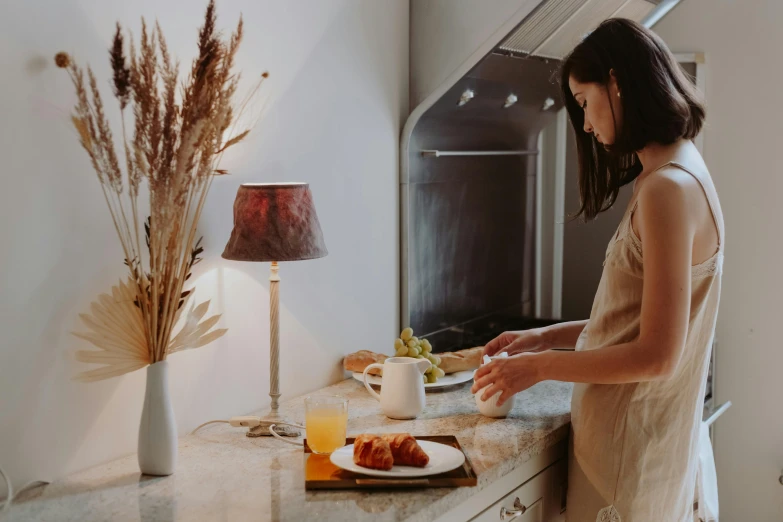 a woman standing in a kitchen preparing food, a still life, trending on pexels, breakfast buffet, emerging from her lamp, profile image, background image