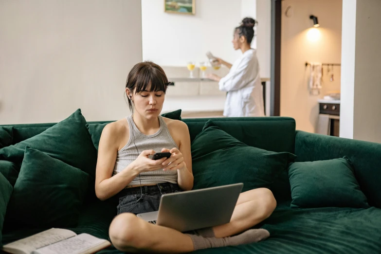 a woman sitting on a couch using a laptop computer, by Adam Marczyński, trending on pexels, happening, two buddies sitting in a room, charli bowater and artgeem, mobile game, bored