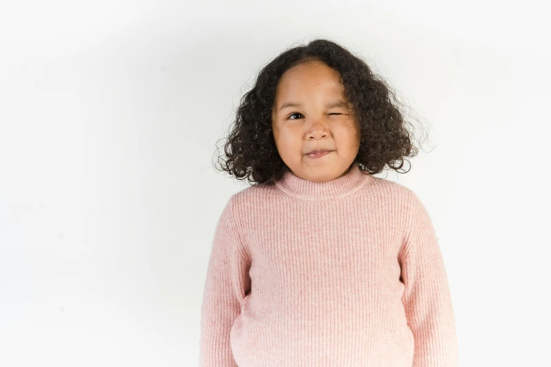 a little girl in a pink sweater posing for a picture, a character portrait, pexels contest winner, ( ( brown skin ) ), slightly overweight, mixed race, promotional image