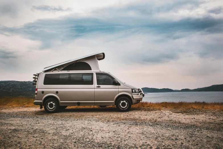 a van parked next to a body of water, unsplash, hurufiyya, soft top roof raised, plain background, king of the hill, exterior photo