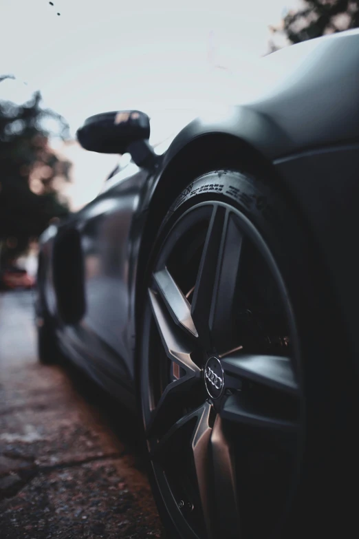 a black sports car parked on the side of the road, pexels contest winner, realism, black wheel rims, gunmetal grey, instagram story, close up shots