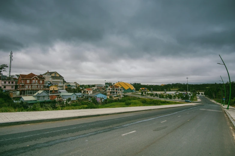 a street lined with lots of houses under a cloudy sky, a portrait, unsplash, vietnam, neo norilsk, highway, landscape photo