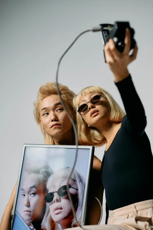 a woman taking a picture of another woman with a camera, a polaroid photo, inspired by Wang Duo, trending on pexels, pop art, white hair floating in air, hito steyerl, wearing black frame glasses, jin shan and ross tran