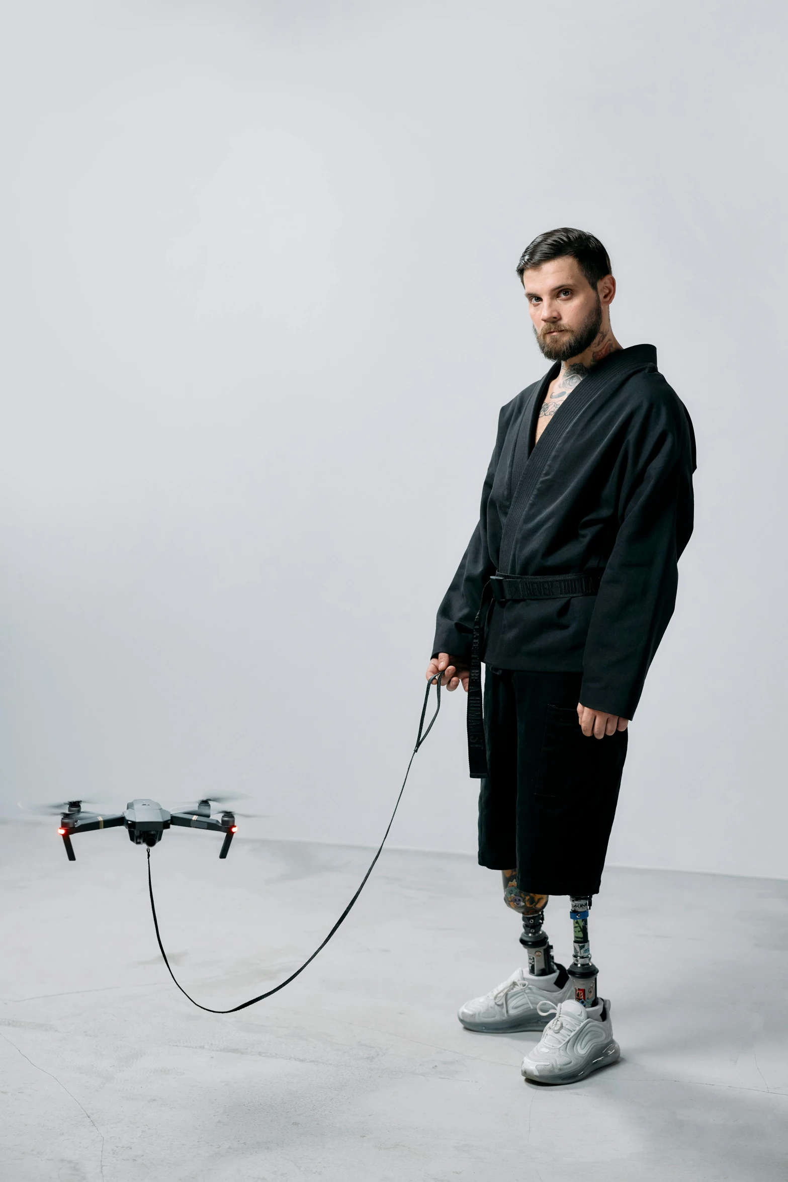 a man standing in a room with a remote control, unsplash, neo-dada, wearing a flying jacket, robotic limbs on floor, wearing a tracksuit, uav