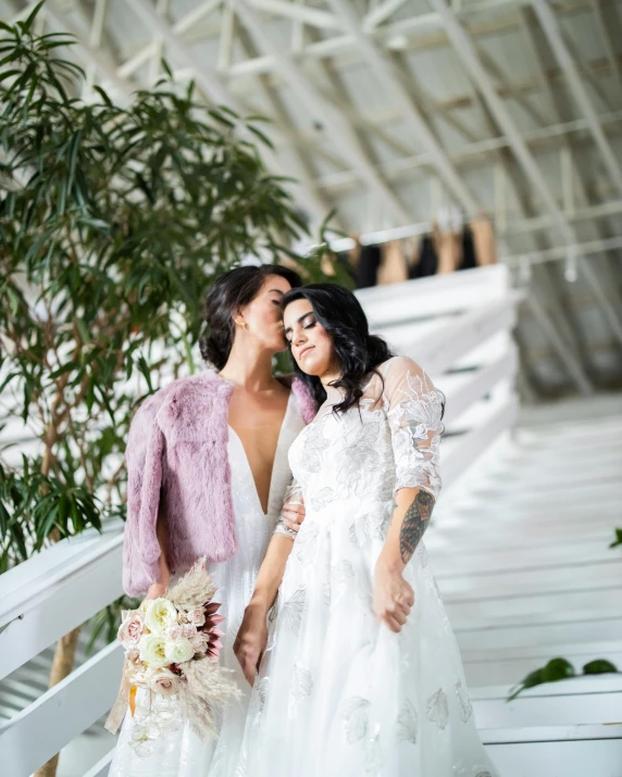 a couple of women standing next to each other, wearing a wedding dress, wearing a fancy jacket, lush vista, thumbnail