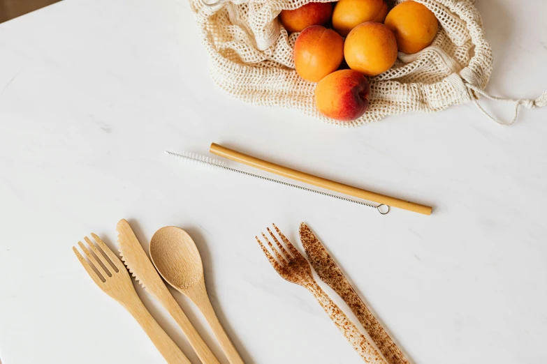 a white table topped with wooden utensils and wooden spoons, unsplash, peaches, bamboo, background image, rubbish