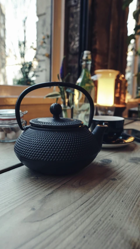 a tea pot sitting on top of a wooden table, inspired by Sesshū Tōyō, unsplash contest winner, low quality photo, thumbnail