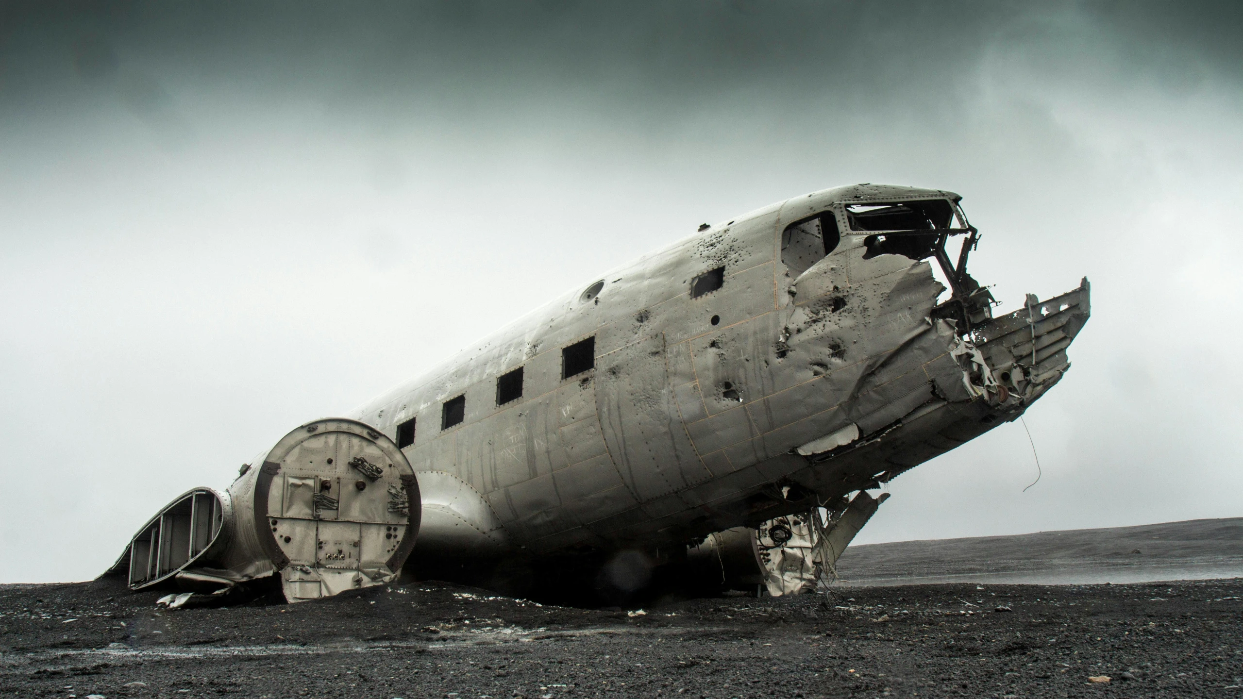 a large airplane sitting on top of a dirt field, by David Begbie, pexels contest winner, shipwreck, reykjavik, 1 9 2 0's, grey