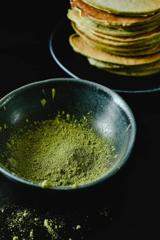 a bowl of green tea next to a stack of pancakes, trending on unsplash, process art, powder, high angle close up shot, panorama, high quality product image”