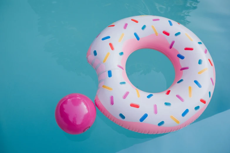 an inflatable donut floating in a pool, unsplash, slide show, pink and blue, paddle and ball, iconic design
