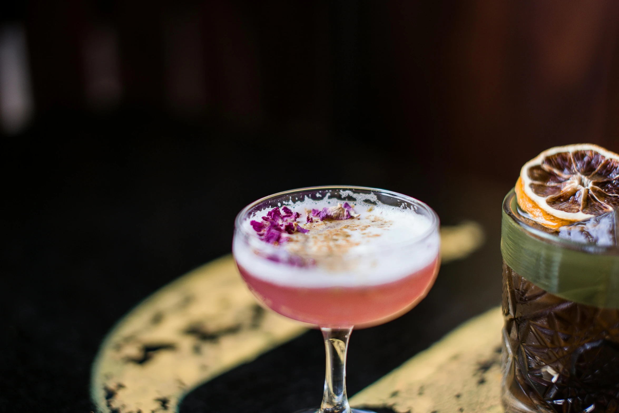 a couple of drinks sitting on top of a table, by Lee Loughridge, unsplash, renaissance, the cheshire cat, cosmopolitan, manuka, in house