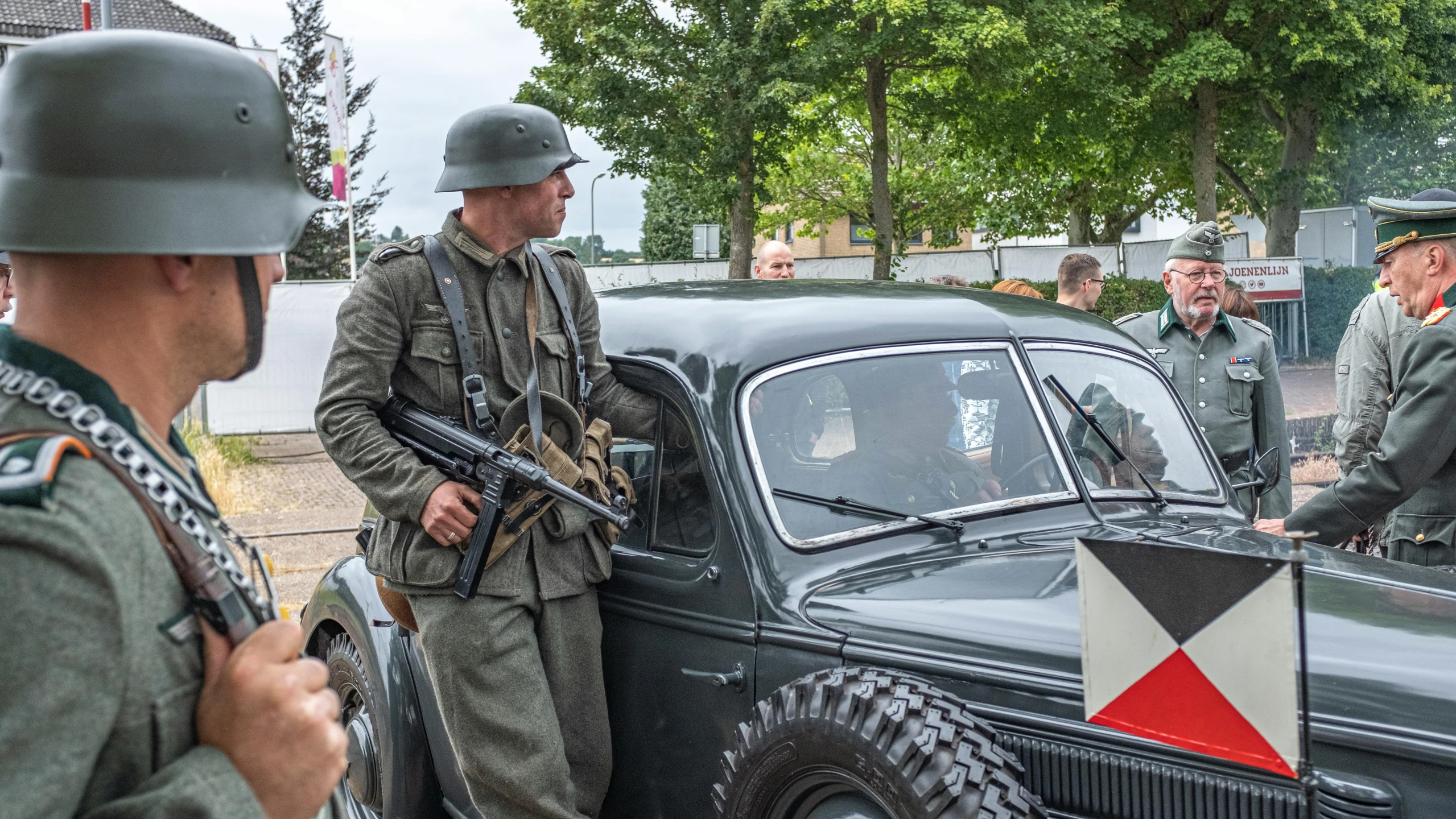 a group of men that are standing in front of a car, set in ww2 germany, full soldier clothing, information, highlight