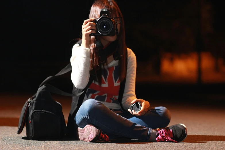 a woman sitting on the ground taking a picture with a camera, by David Donaldson, pexels contest winner, night time footage, teenage girl, casually dressed, royal photo