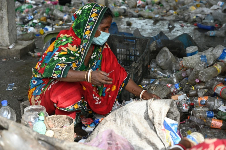 a woman sitting in front of a pile of garbage, a picture, faridah malik, thumbnail, slide show, hindu