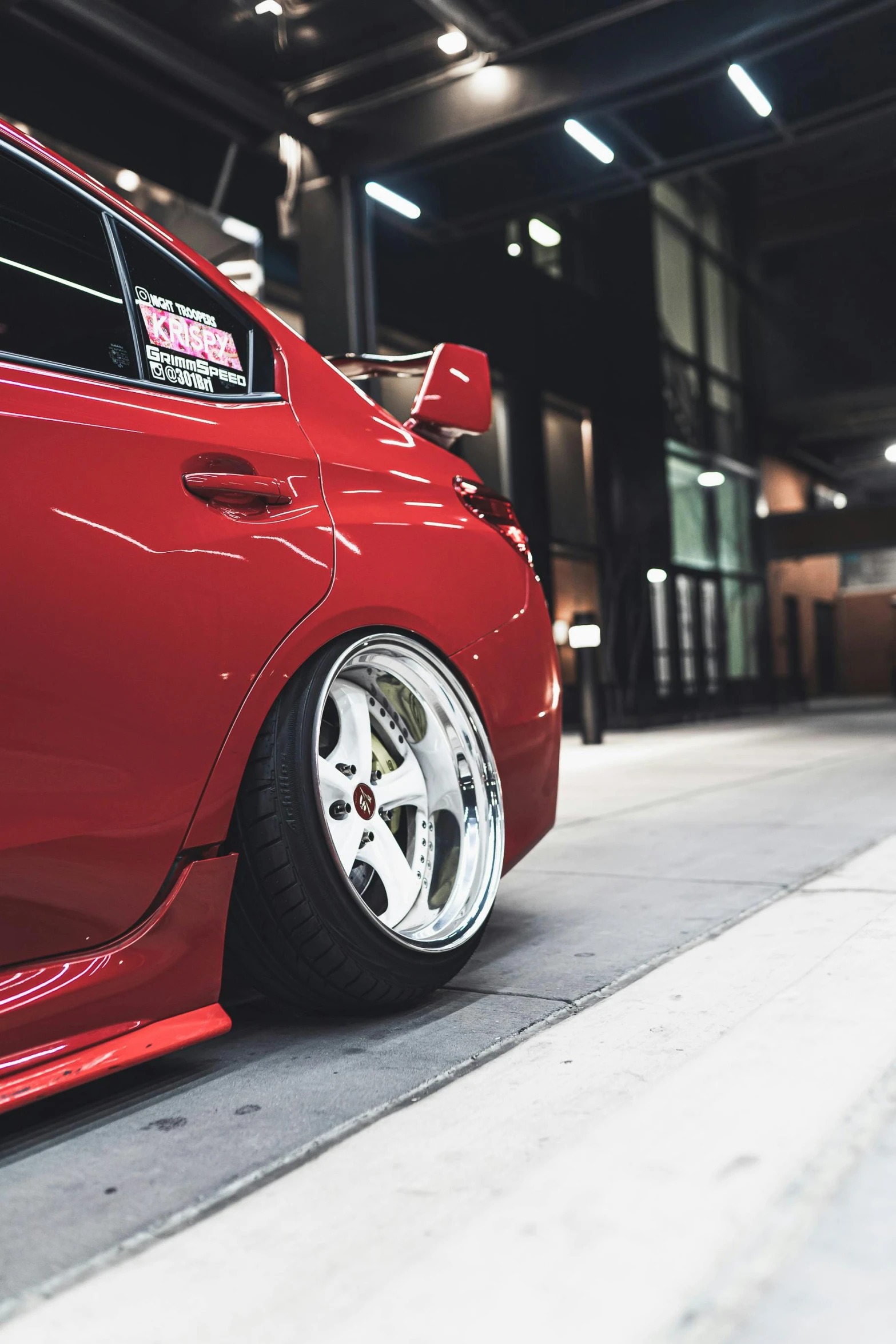 a red car parked inside of a building, inspired by An Gyeon, renaissance, detailed alloy wheels, jdm, bottom body close up, fujifilm”