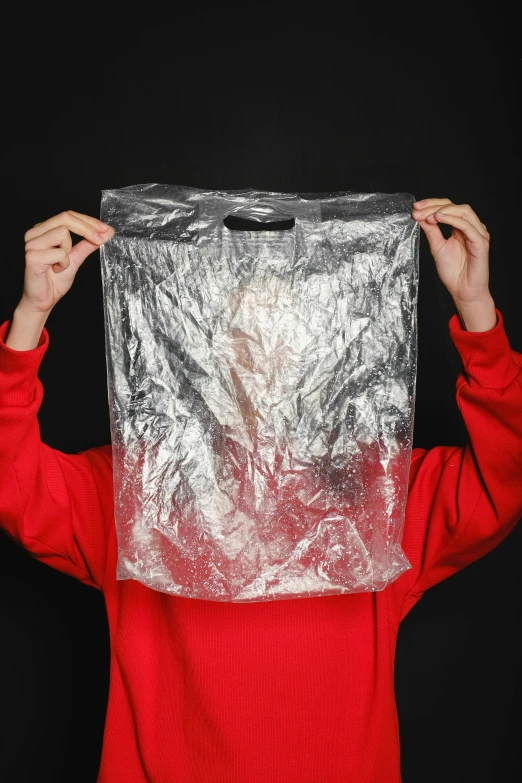 a person holding a plastic bag over their head, shiny silver, 4l, no - text no - logo, volcanic