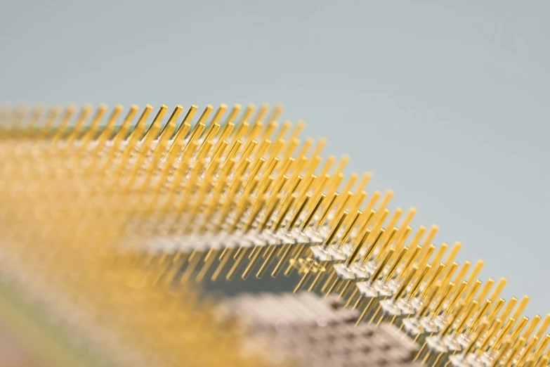 a close up of a comb on a table, a macro photograph, by Jennifer Bartlett, computer art, gold cables, sensor array, spines and towers, detailed product shot
