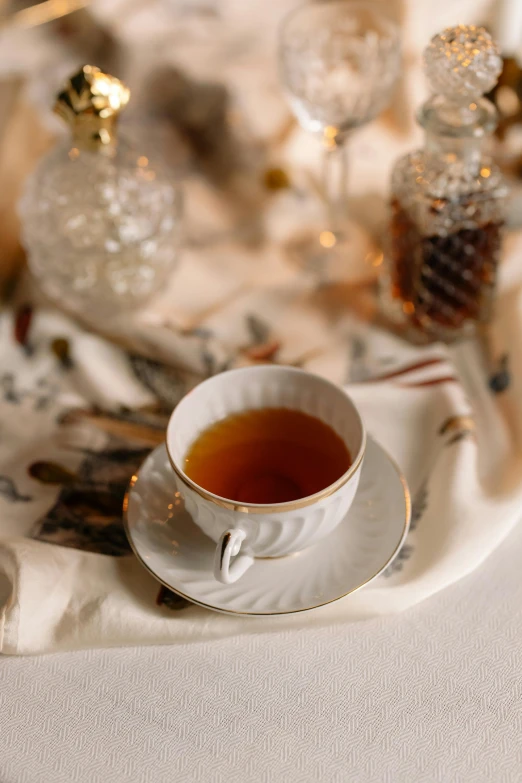 a cup of tea sitting on top of a table, by Julia Pishtar, trending on pexels, renaissance, festive, linen, caramel, classic portrait