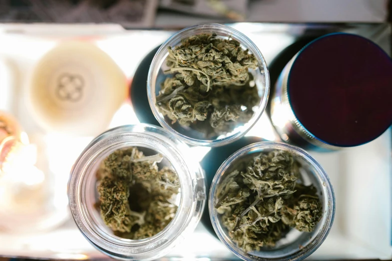 three jars of marijuana sitting on top of a tray, pexels, dials, crisp details, thumbnail, lush