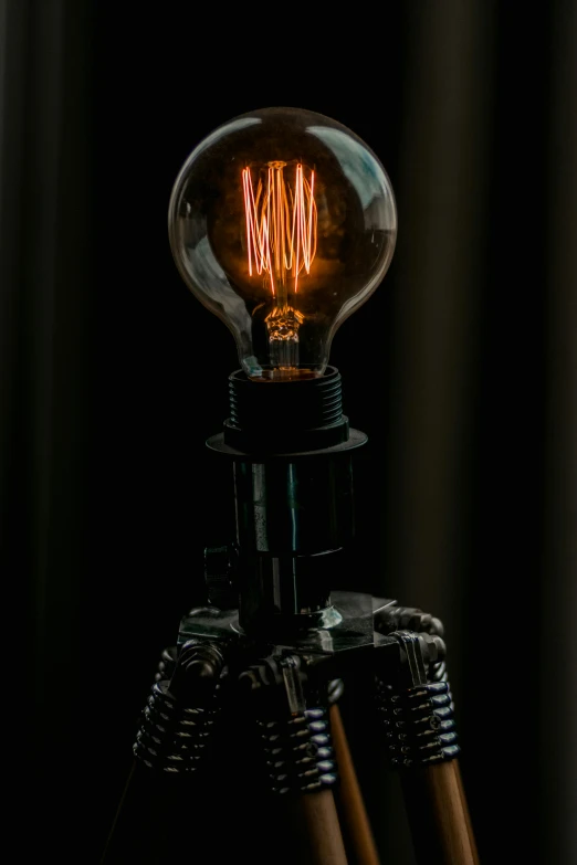 a light bulb sitting on top of a tripod, a portrait, by Adam Marczyński, unsplash, kinetic art, cyber steampunk 8 k 3 d, small nixie tubes, close - up studio photo, made of lasers