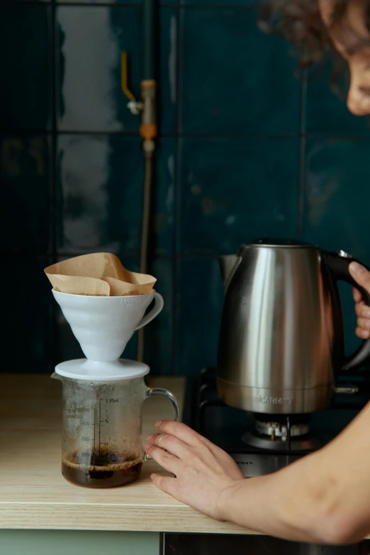 a woman is preparing a cup of coffee, a still life, by Julia Pishtar, trending on unsplash, cone shaped, stainless steel, gif, 278122496