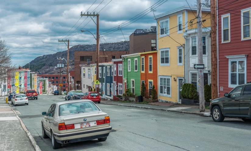 a street filled with lots of parked cars, by Raymond Normand, pexels contest winner, renaissance, colorful houses, port, edward hopper vibe, hilly road