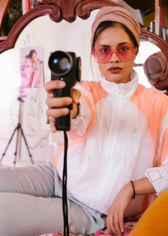 a woman taking a picture of herself in a mirror, a polaroid photo, trending on pexels, visual art, holding a blaster, pastel clothing, wearing futuristic, woman with rose tinted glasses
