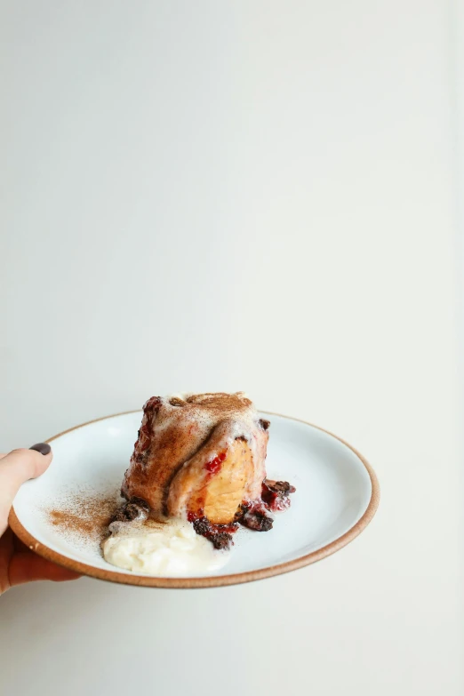 a person holding a plate with a piece of cake on it, inspired by Richmond Barthé, unsplash, in the shape of a cinnamon roll, raspberry, melbourne, front shot