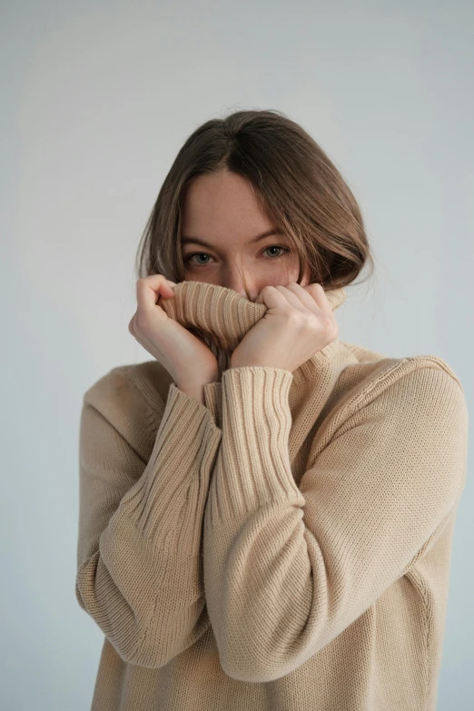 a woman covering her face with her hands, trending on pexels, visual art, wearing turtleneck, beige, happy fashion model, portrait sophie mudd