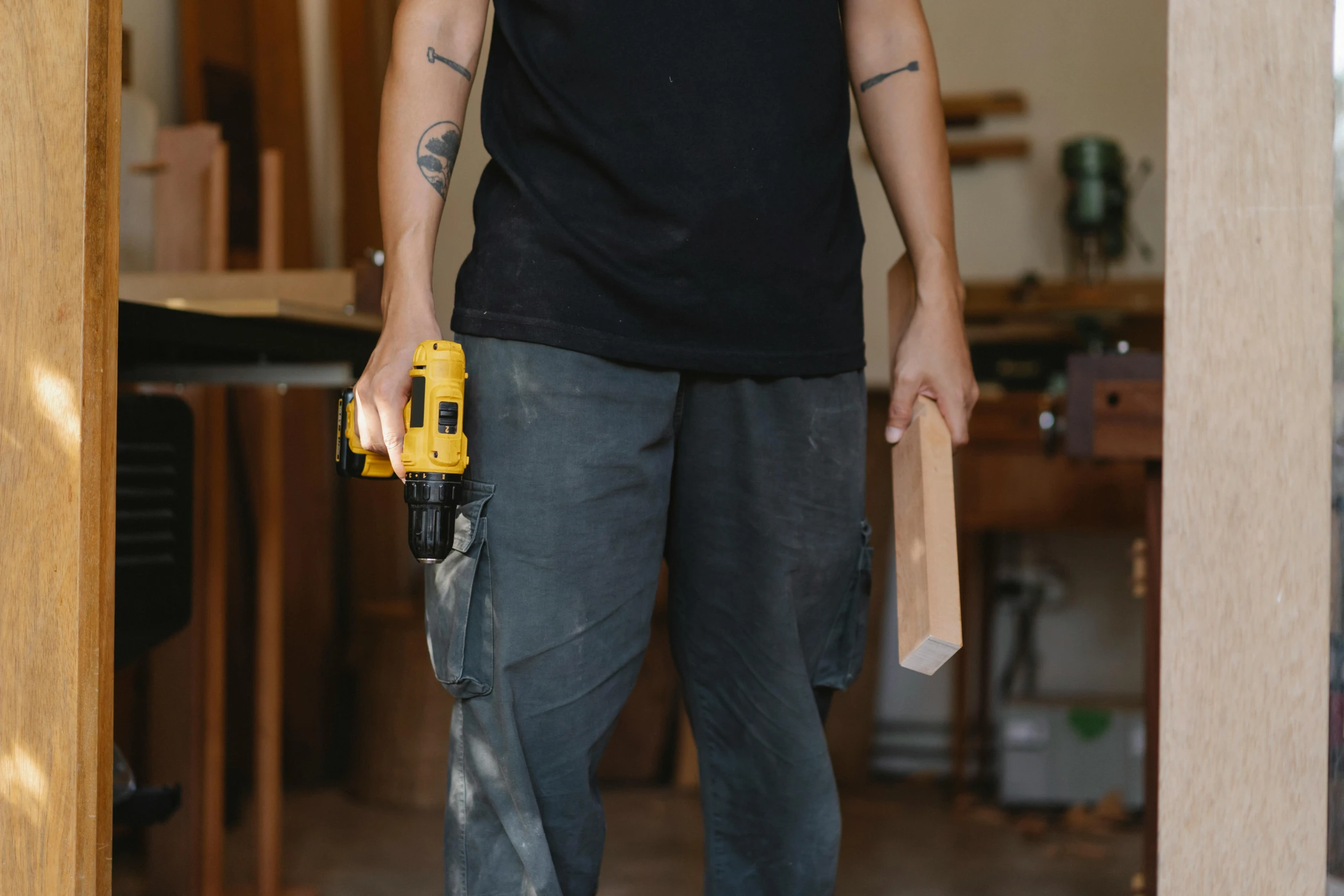 a man holding a power drill in his hand, by Carey Morris, pexels contest winner, wearing cargo pants, holding a wooden staff, lachlan bailey, no - text no - logo