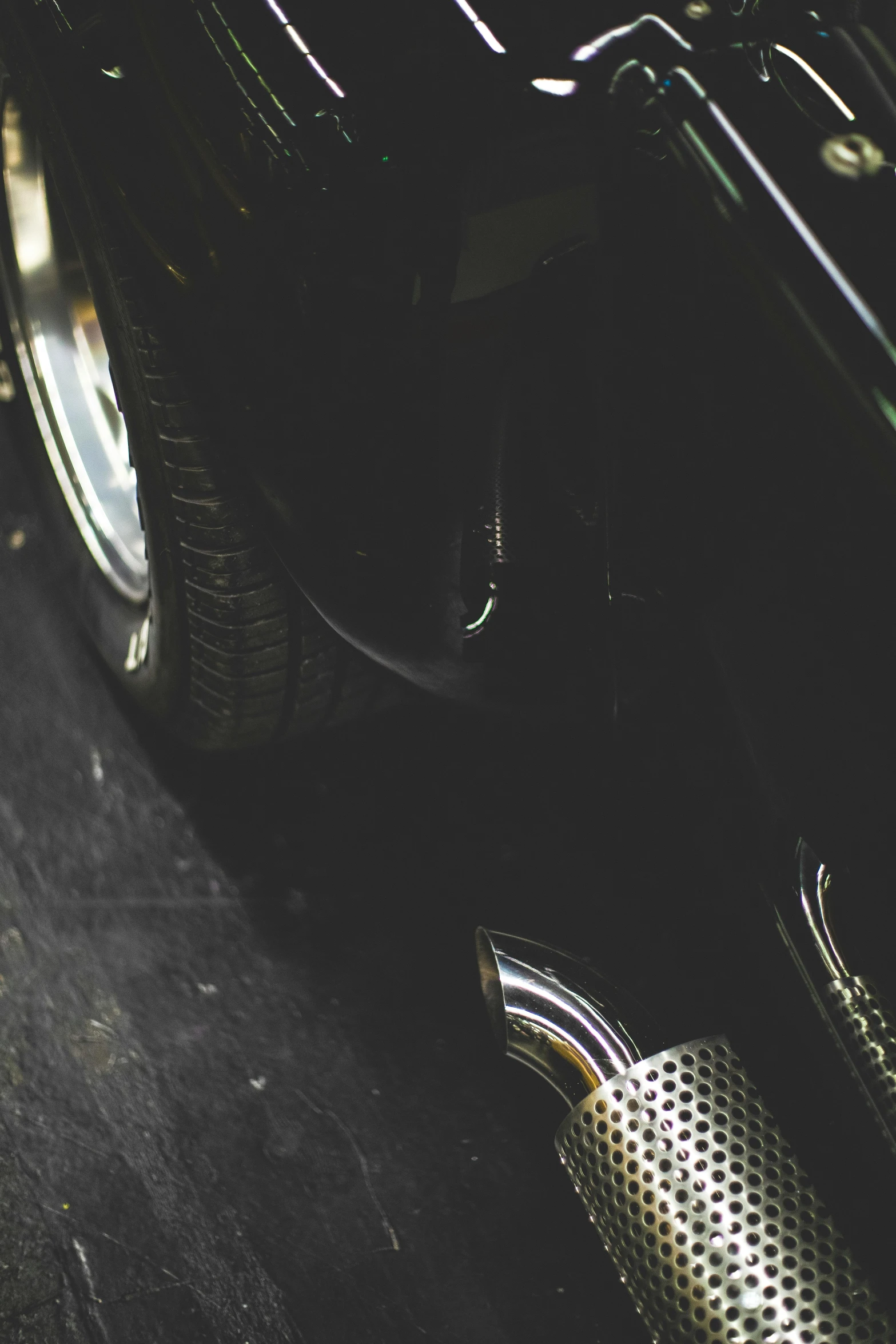 a close up of a car's exhaust pipe, by Matt Cavotta, unsplash, black loafers, ( ( ( ( ( jaguar e - type car, grainy vintage, instagram photo