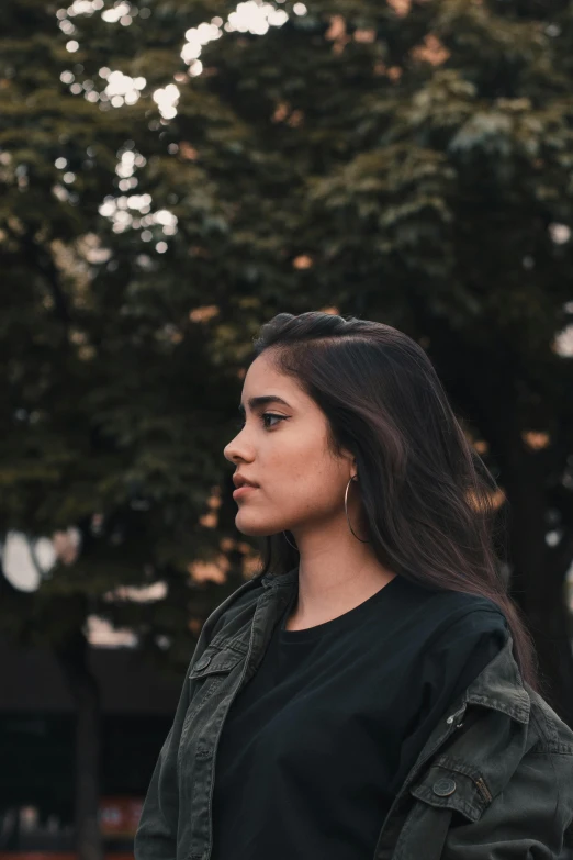 a woman standing in front of a tree, pexels contest winner, realism, prominent jawline, teenager girl, alanis guillen, wearing jacket