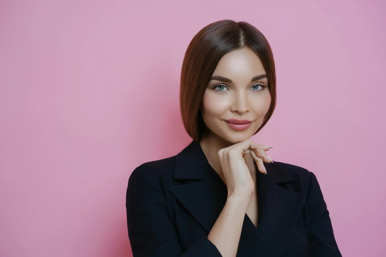 a beautiful young woman posing in front of a pink wall, a character portrait, trending on pexels, woman in black business suit, with a bob cut, photoshoot for skincare brand, hand on her chin