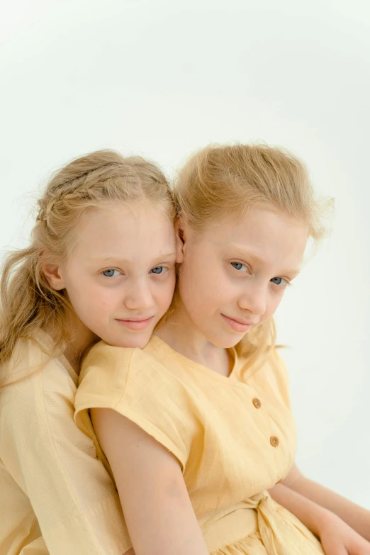 a couple of young girls sitting next to each other, slight yellow hue, arm around her neck, sergey krasovskiy, adult pair of twins