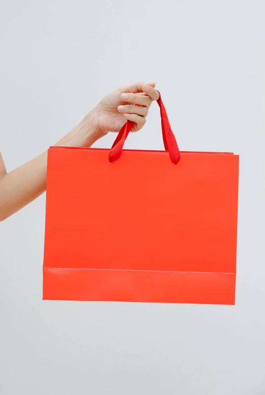 a woman holding a bright red shopping bag, pexels contest winner, minimalism, vibrant but dreary orange, sleek design, no - text no - logo, gif