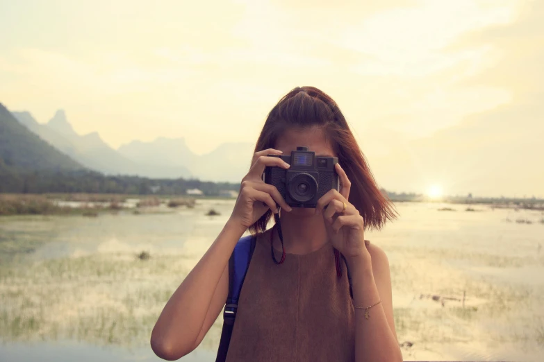 a woman taking a picture with a camera, a picture, inspired by Steve McCurry, unsplash contest winner, medium format. soft light, vacation photo, waist up, summer evening