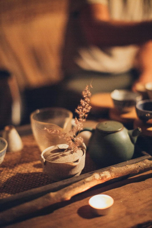 a table topped with bowls of food next to a lit candle, a still life, inspired by Kanō Shōsenin, trending on unsplash, mingei, background: assam tea garden, clay material, drinking, concert